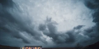 Storm clouds over a lit house, illustrating rising home insurance costs in Ontario